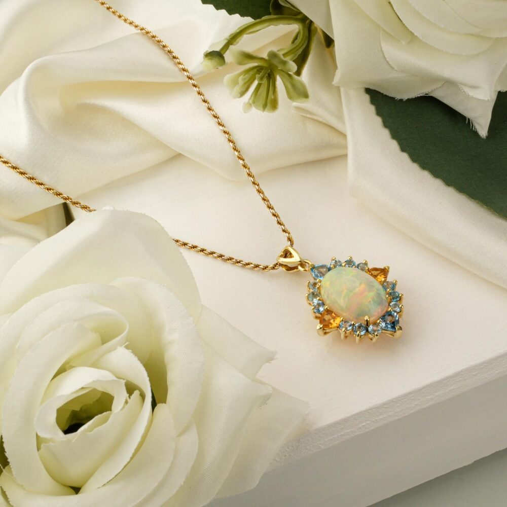Gold-toned 925 silver necklace with opal pendant haloed by citrine and blue topaz.