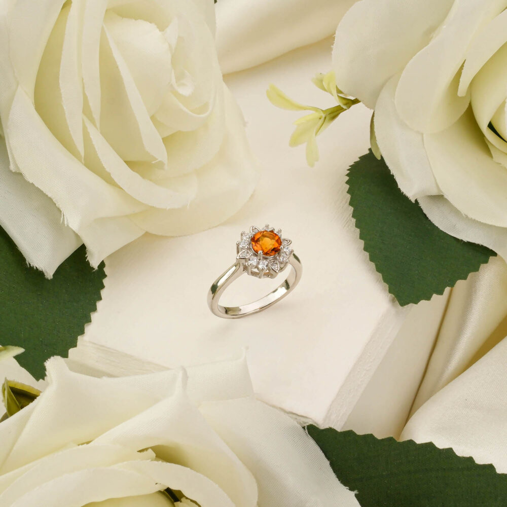 Citrine 925 sterling silver halo ring displayed among white roses.