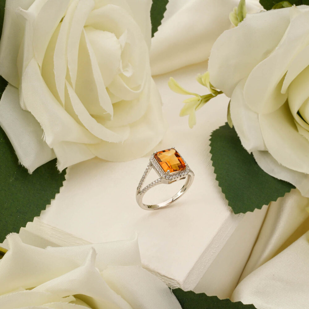 Emerald-cut Citrine 925 sterling silver ring displayed among white roses.