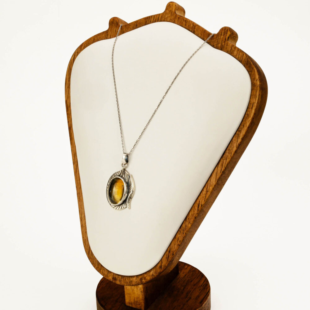 Close-up of oval cabochon citrine in silver bezel.