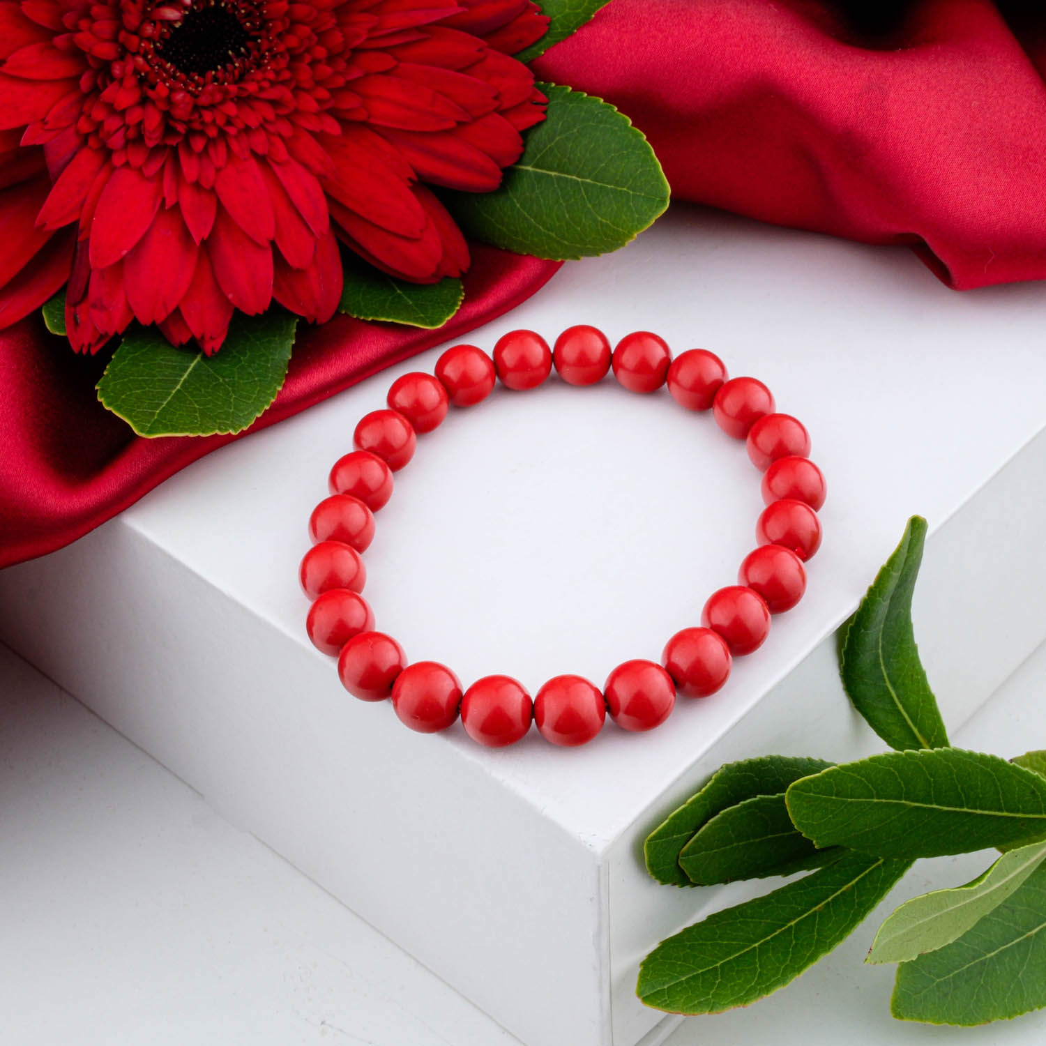 4a-quality-carved-cinnabar-bracelet-8mm A 4A+ quality 8mm natural carved cinnabar beaded bracelet with a bell charm, on a white box.