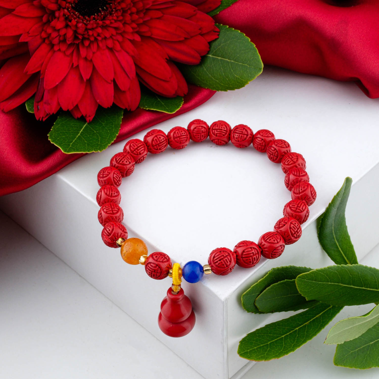 4a-quality-cinnabar-charm-bracelet-6mm A 4A+ quality 6mm natural cinnabar beaded bracelet with a carved charm, on a white box.
