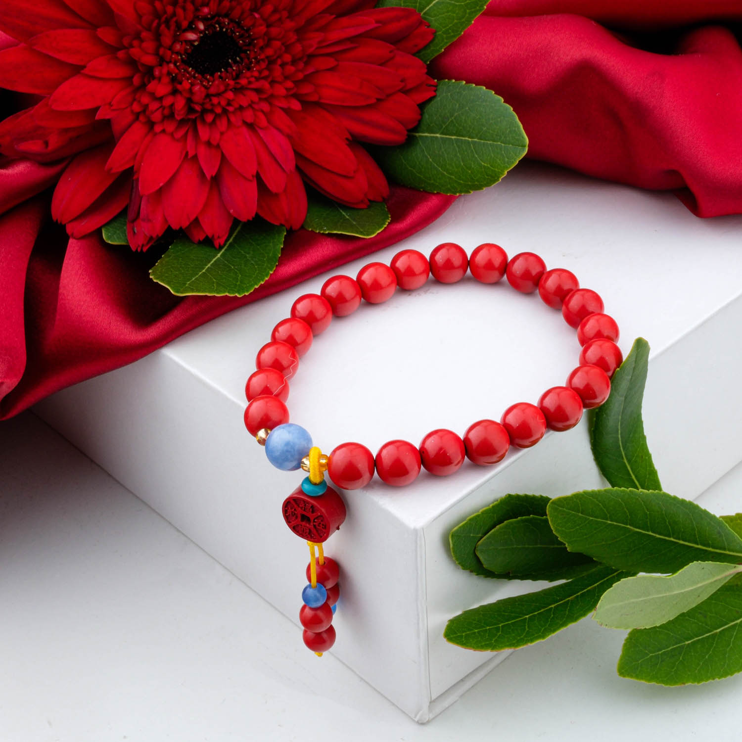 4a-quality-cinnabar-charm-bracelet-6mm A 4A+ quality 6mm natural cinnabar beaded bracelet with a carved charm, on a white box.