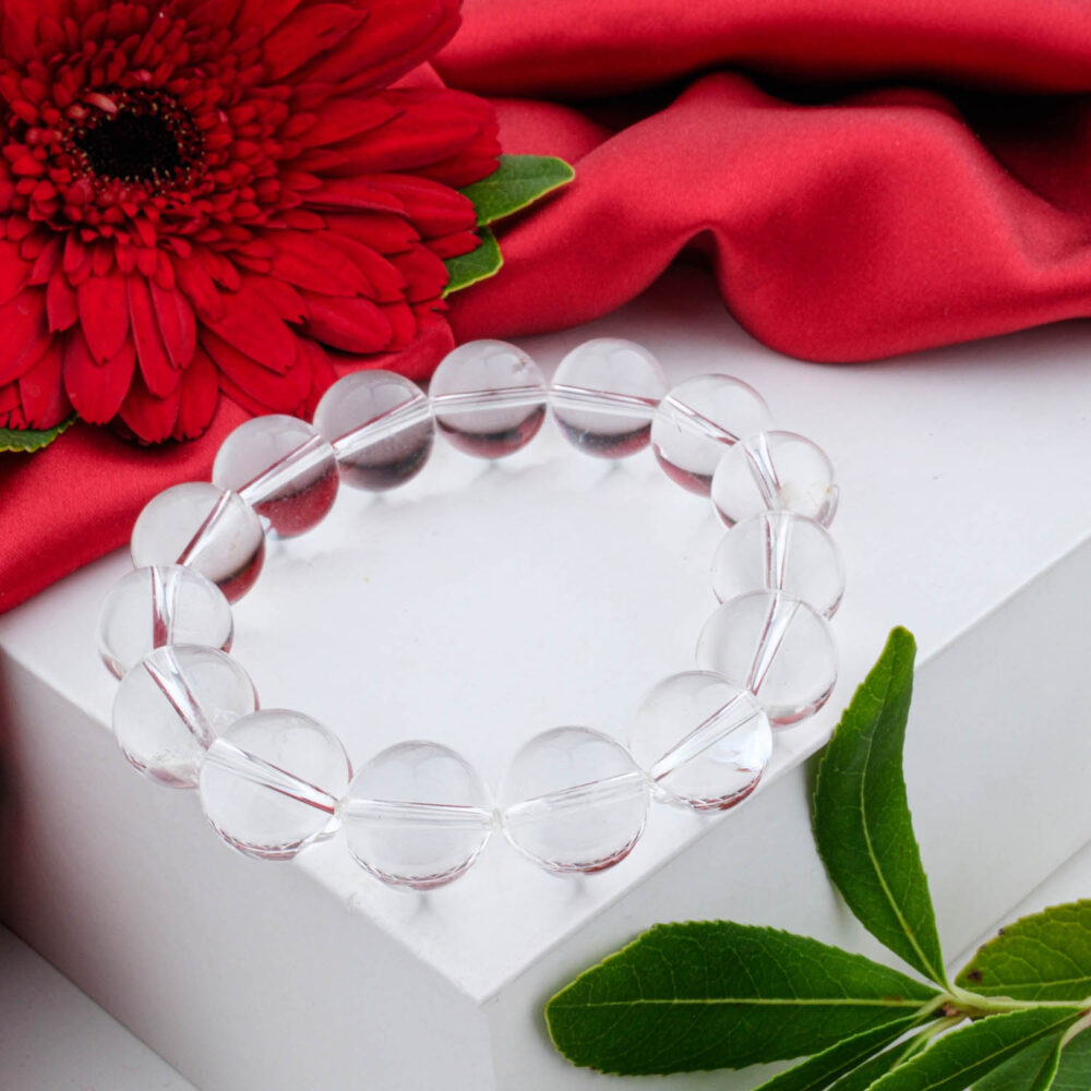 5A+ Grade Clear Crystal Quartz bracelet with large 14-15mm polished beads, on a black box with a red flower.
