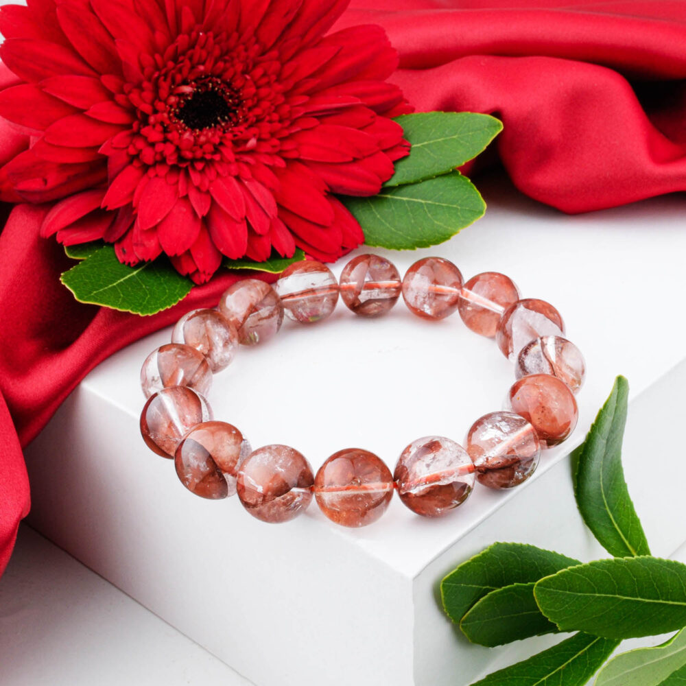 Premium 5A+ Red Hematoid Quartz bracelet (12-13mm) with large clear beads showing red hematite inclusions, on white box.