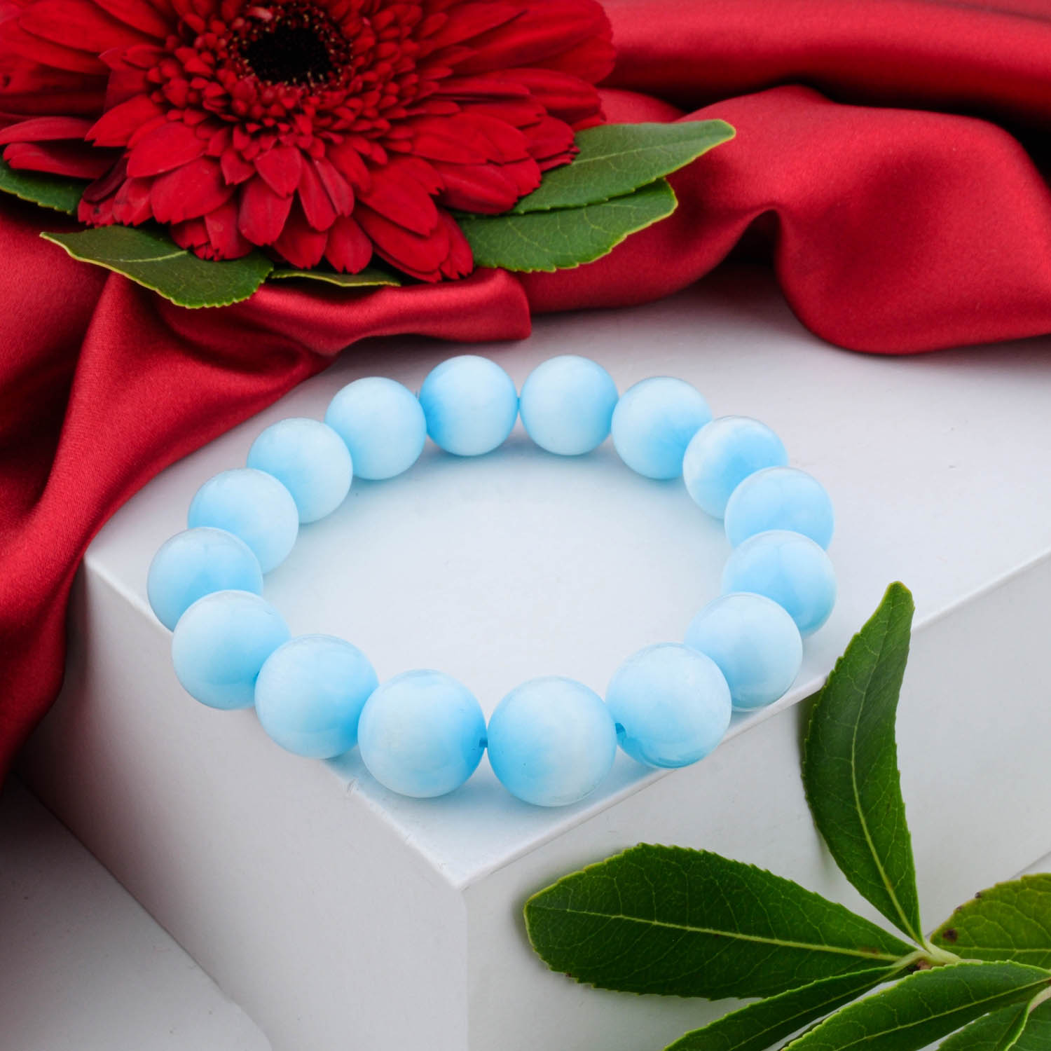 Premium 6A+ Grade Hemimorphite bracelet (12-13mm) with light sky-blue polished beads, shown on a white box.