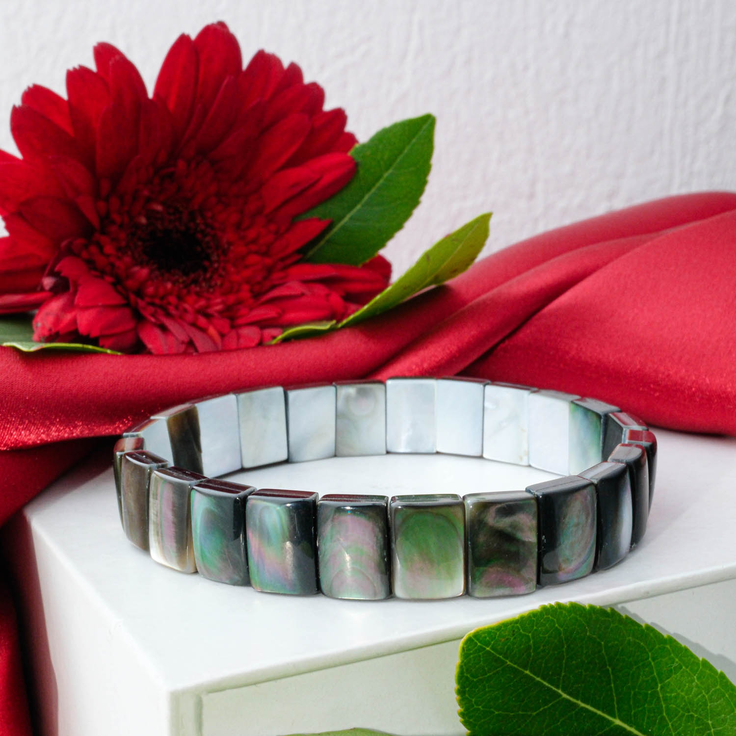 Iridescent Black Mother of Pearl bracelet with dark, shimmering rectangular tile links in Rolex-style, on white box.