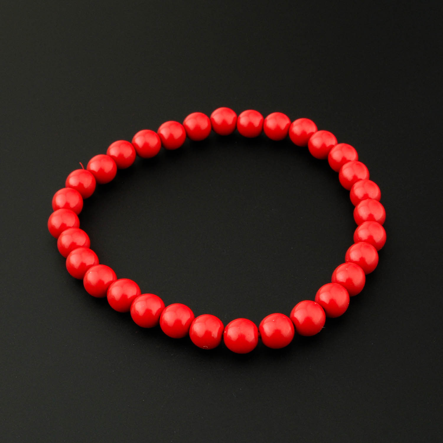 bracelet-en-cinabre-naturel-6mm Ein 10mm natürliches Schneeflocken-Obsidian-Perlenarmband mit Silberschließe auf weißem Seidenstoff. (Image shows Snowflake Obsidian)