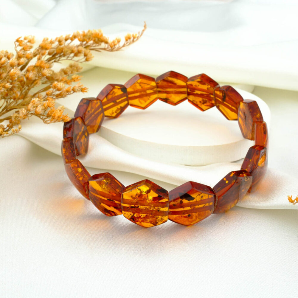 Certified faceted amber panel bracelet for adults in warm honey tone on neutral fabric