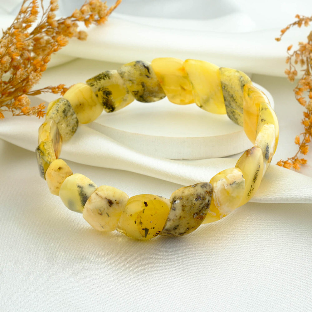 Certified amber “Rolex” panel bracelet in butterscotch tones with natural inclusions on neutral fabric