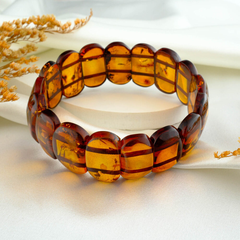 Certified amber “Rolex” panel bracelet for adults in honey–cognac tones on neutral fabric