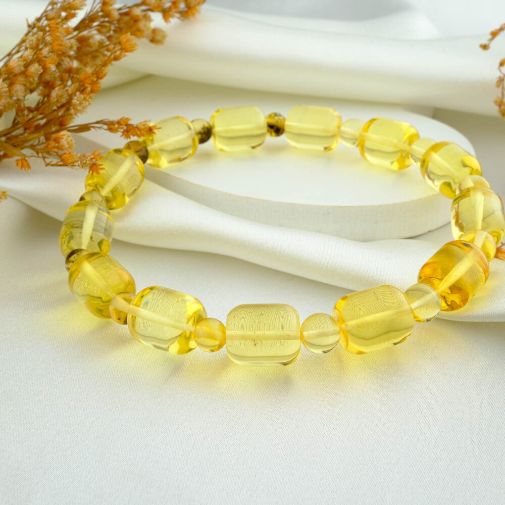 Certified transparent amber capsule bracelet for adults in lemon-yellow on neutral fabric
