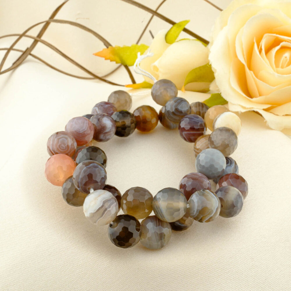 A double-wrapped strand of 10mm faceted Botswana agate beads with fine grey, brown, and white bands.