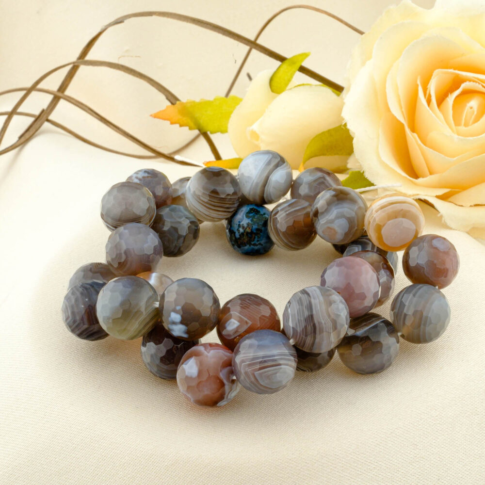 A double-wrapped strand of 12mm faceted Botswana agate beads with fine grey, brown, and white bands.