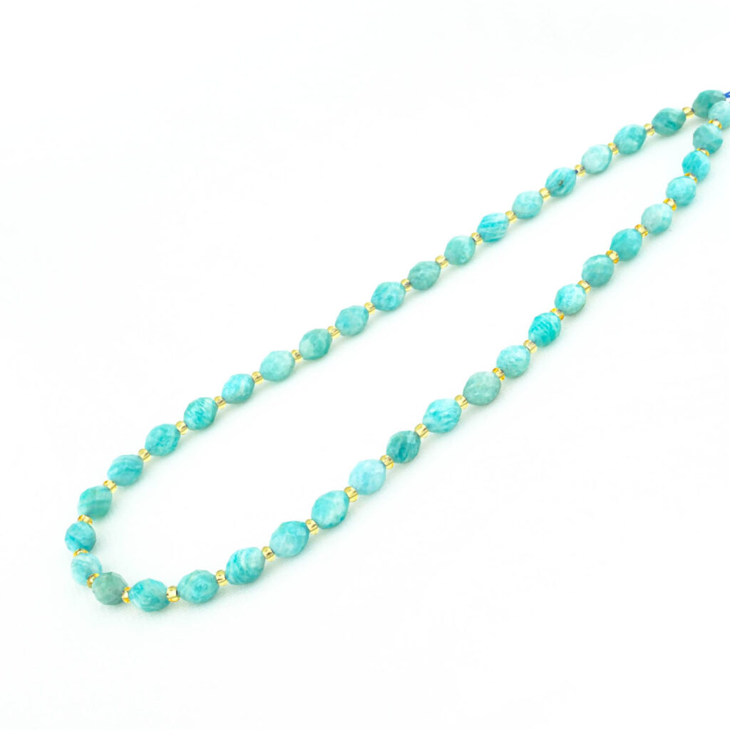 Hebra de cuentas de amazonita ovaladas y facetadas con un color azul-verde vibrante y acentos de oro.