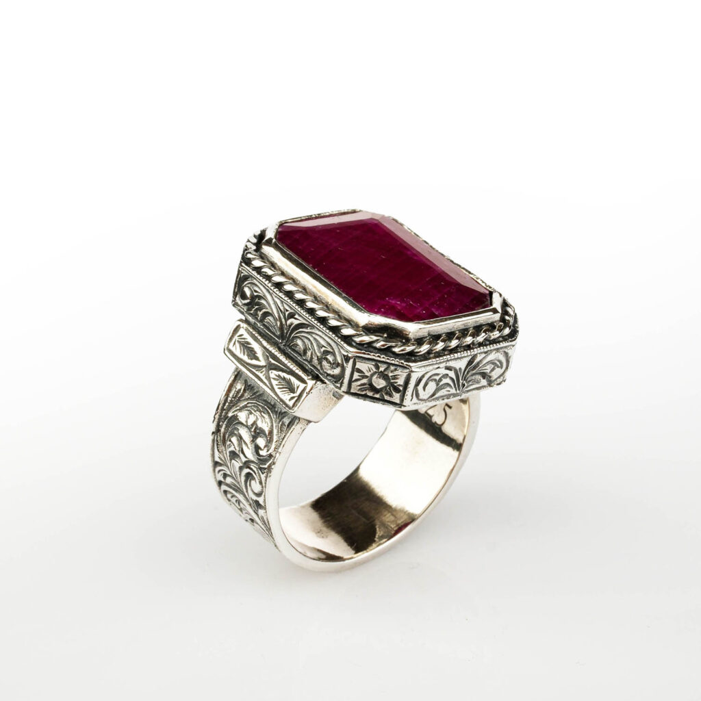 Side view of the large ruby men's ring showing the intricate artisan engraving on the sterling silver band.