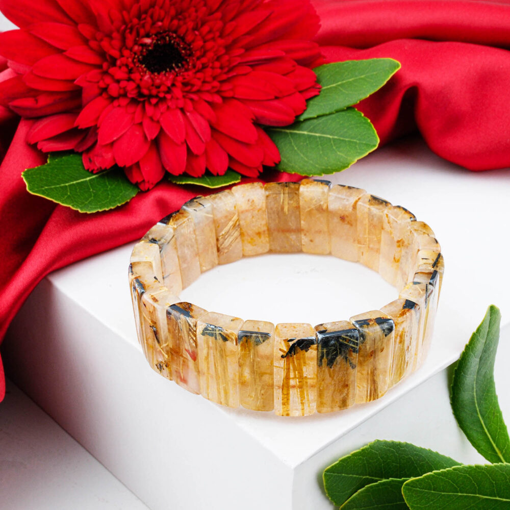 Large Golden Rutilated Quartz bracelet with clear, faceted Rolex-style links showing golden rutile needles, on white box.