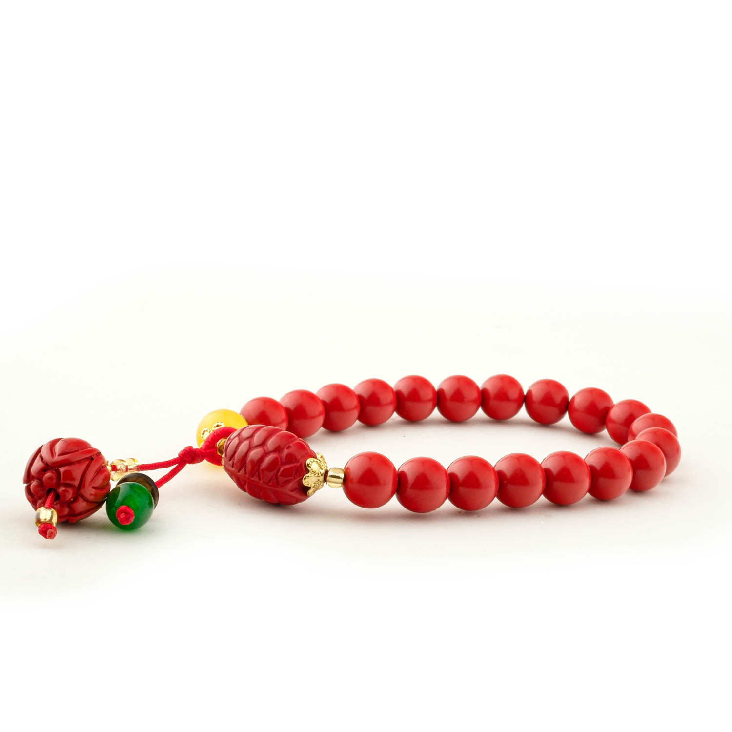 natural-cinnabar-stone-bracelet-8mm-charm Close-up of an 8mm red cinnabar bracelet with carved beads and a bell charm, on a white box with a red flower.
