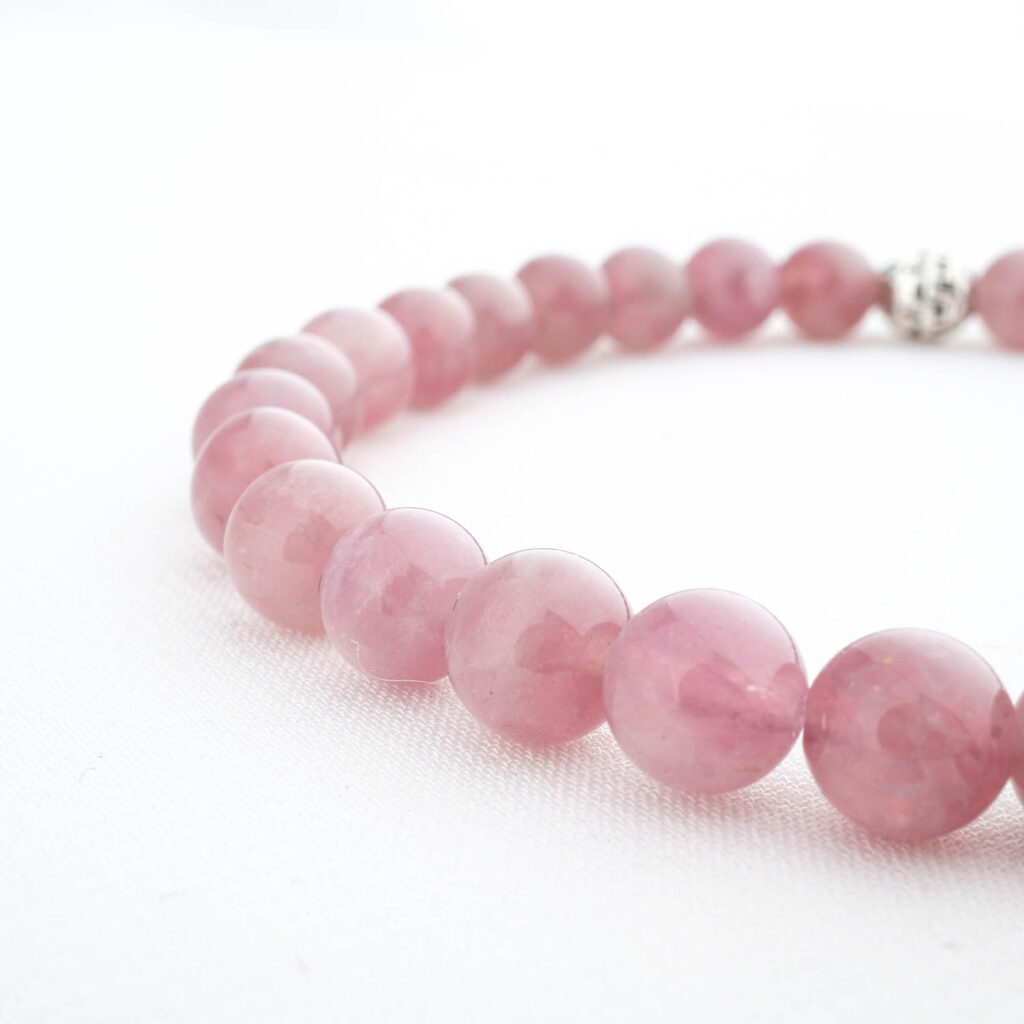 Bracelet de perles en améthyste naturelle facettée de 6mm, qualité 5A+, avec fermoir argent, sur tissu soie blanc.