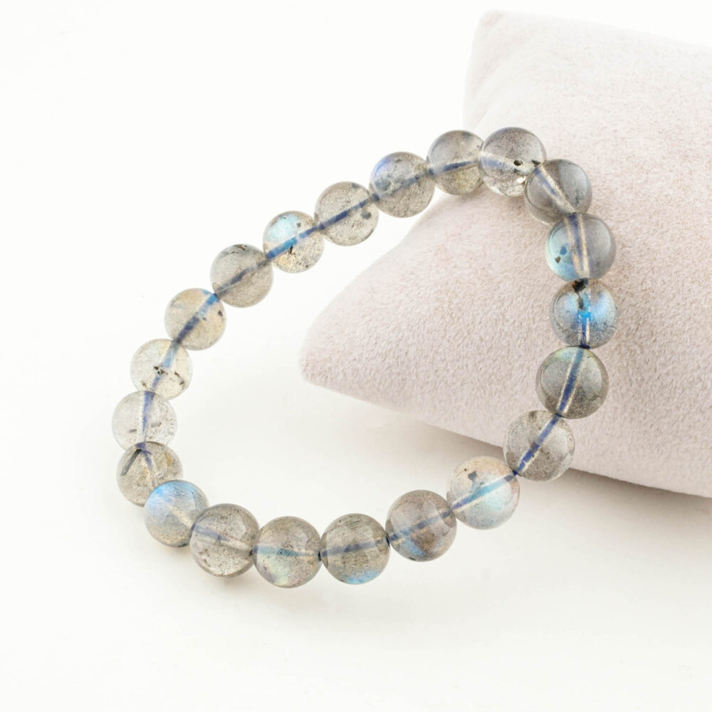 Pulsera de Labradorita 6A+ (7-8mm) con cuentas grises mostrando destellos azul-verde, sobre caja blanca.