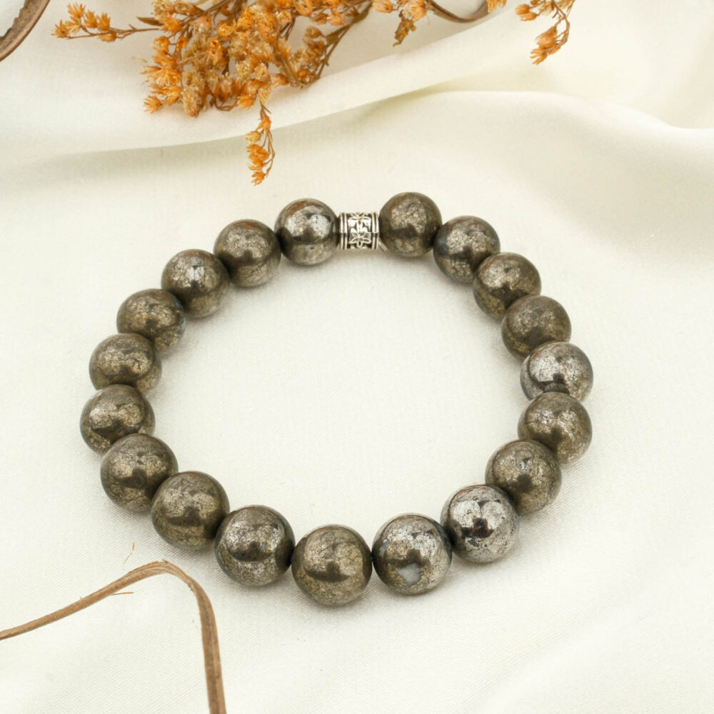 Pyrite 10mm natural stone beaded bracelet on neutral fabric