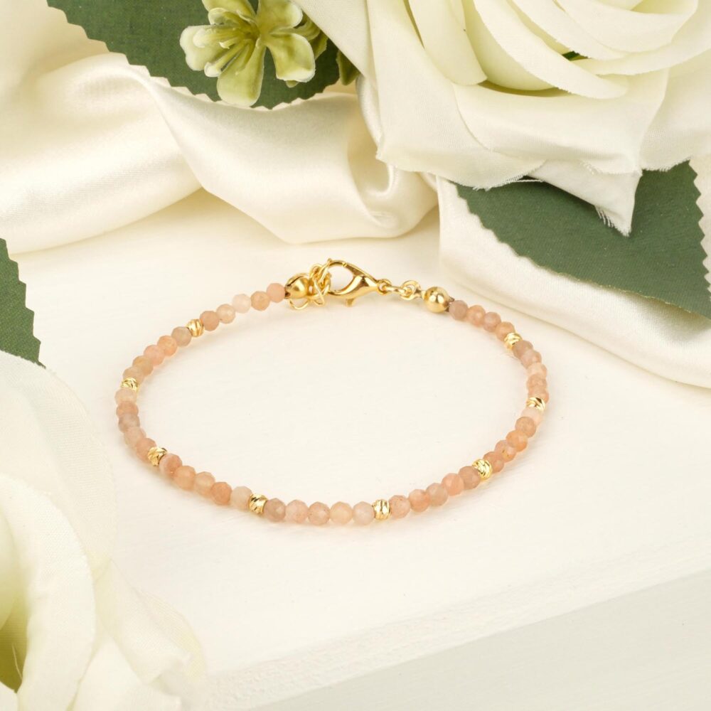 Delicate 2-3mm faceted sunstone bracelet with gold-tone steel accents on white