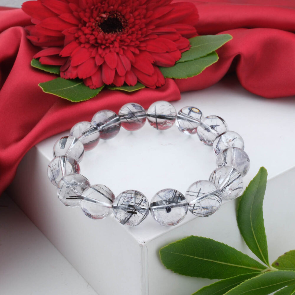 6A+ quality clear black rutilated quartz (tourmalinated) bracelet with 10-11mm beads on white