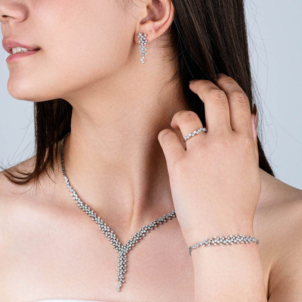 Complete silver jewelry set with blue zircon necklace, bracelet, and drop earrings on black background