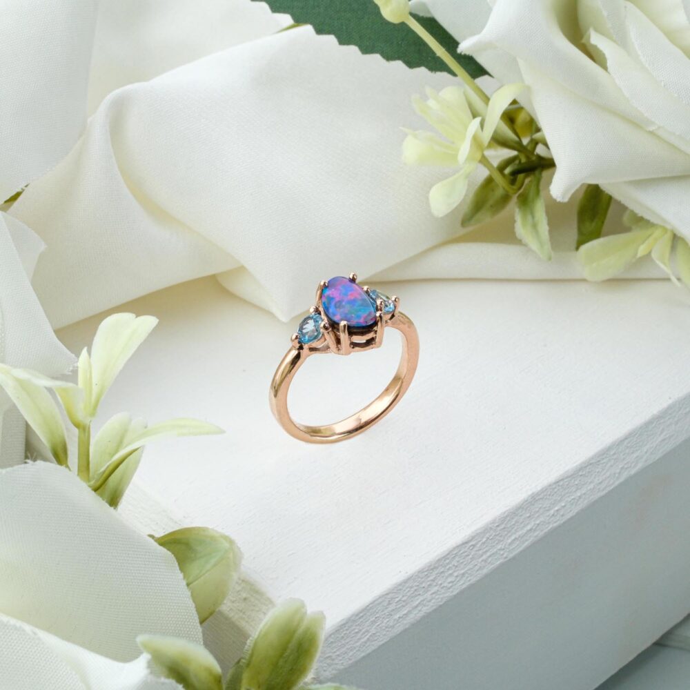 Marquise-cut Australian Boulder Opal ring with Blue Topaz side stones in gold-plated 925 silver on white