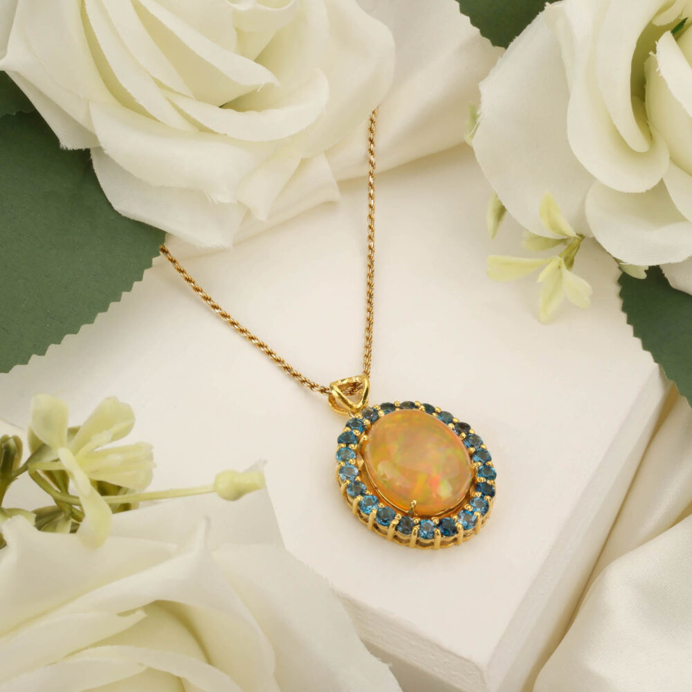 Marquise-cut Australian Boulder Opal pendant with London Blue Topaz accents in gold-plated silver on white