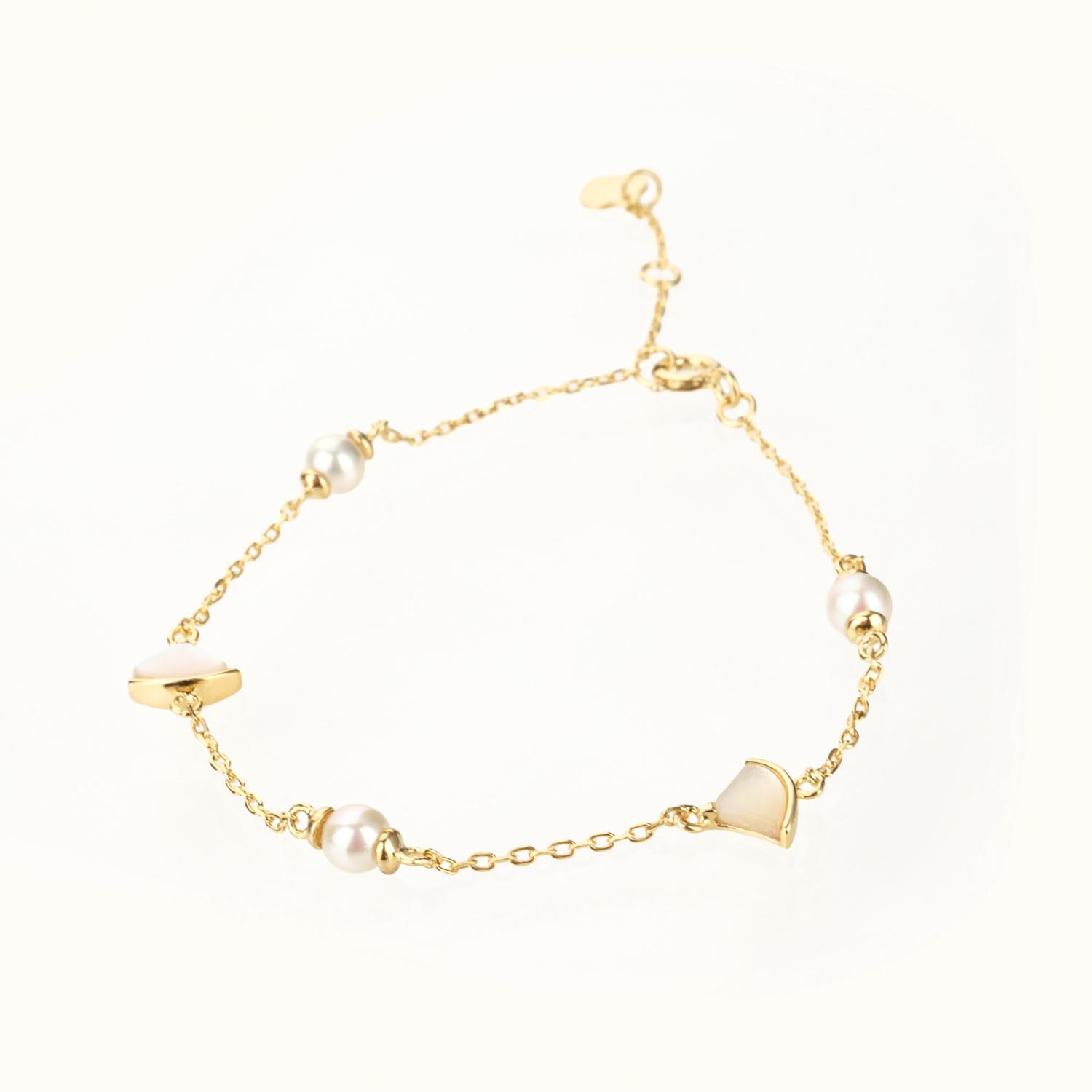 bracelet-perle-petale-nacre-or-argent-925 Pulsera de perla y charm de pétalo de nácar en plata 925 con baño de oro sobre fondo blanco