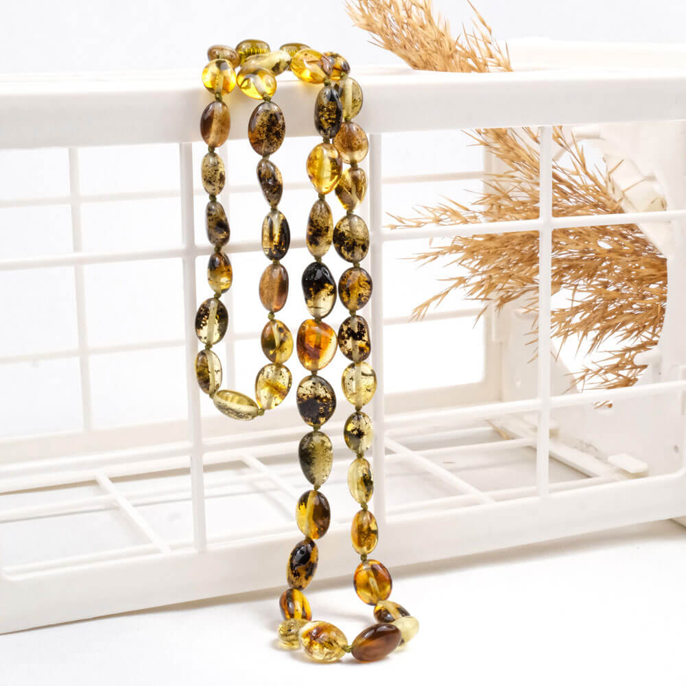 Certified genuine Baltic amber necklace for adults with polished green and cognac baroque beads in a wooden box.
