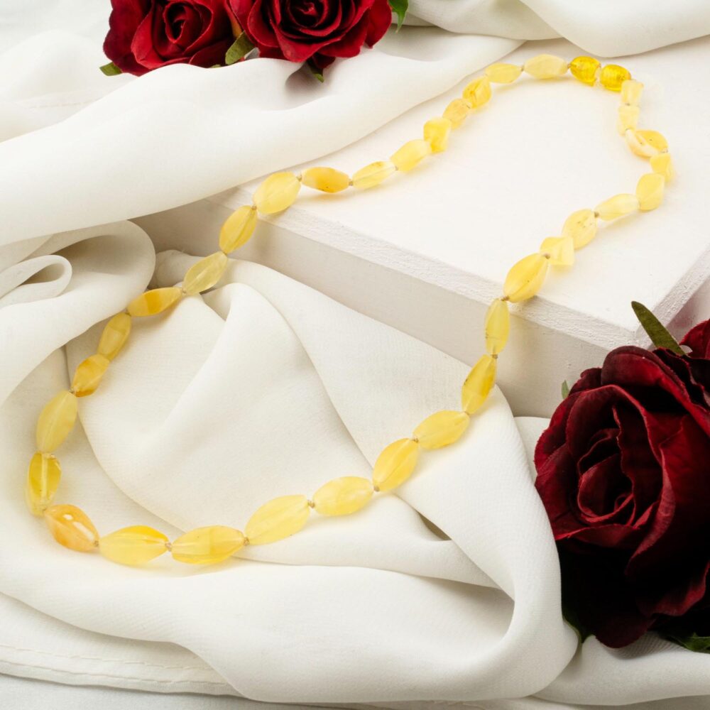 Certified genuine adult amber necklace with lemon yellow beads on white background