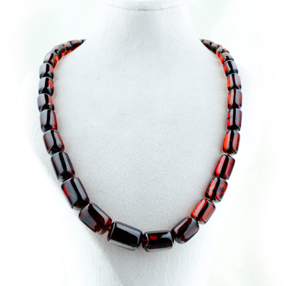 Collar de ámbar genuino certificado con cuentas en forma de cápsula color cereza oscura sobre fondo blanco