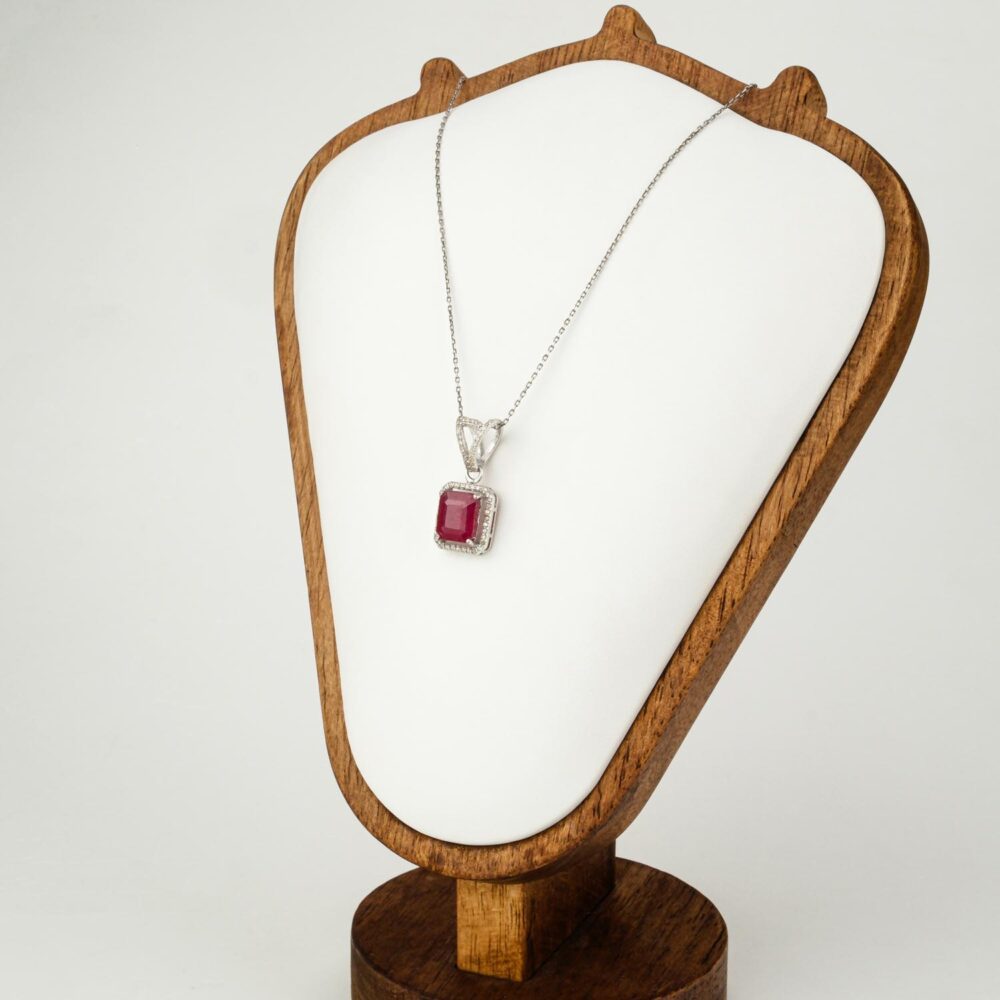 Collar con colgante de rubí talla esmeralda con halo en plata 925 sobre fondo blanco
