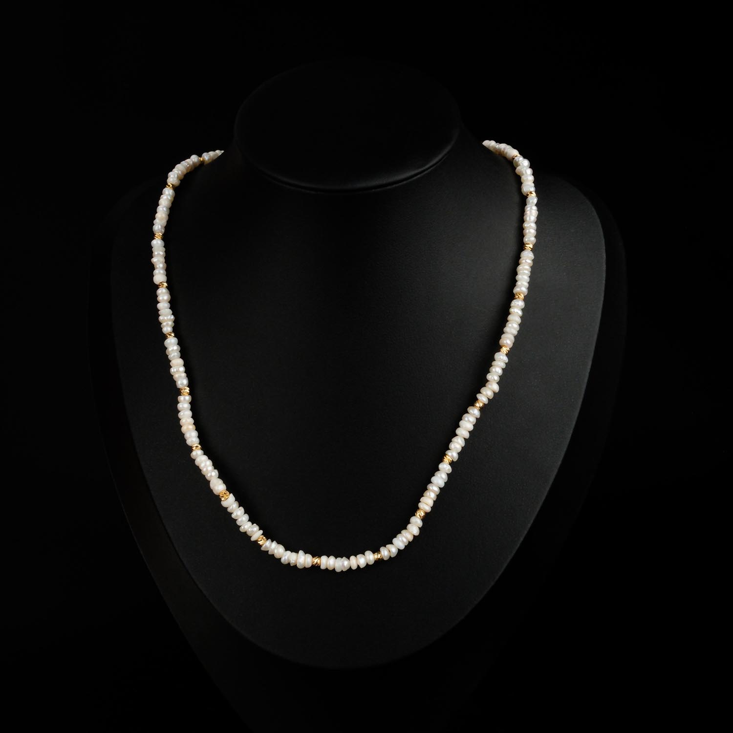 collier-mini-perles-eau-douce-acier-dore Collier délicat de mini perles d'eau douce avec perles en acier doré sur fond noir