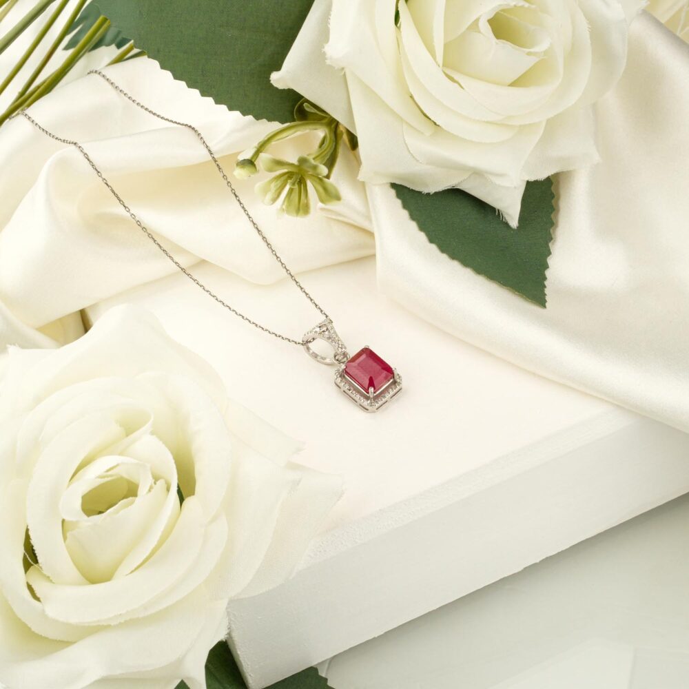 Emerald-cut ruby halo pendant necklace in 925 sterling silver on white display