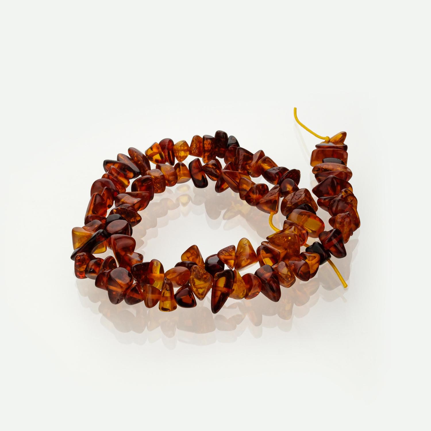 fil-ambre-brut-eclats-cognac Fil d'éclats d'ambre brut (style pierre cassée) sur présentoir blanc