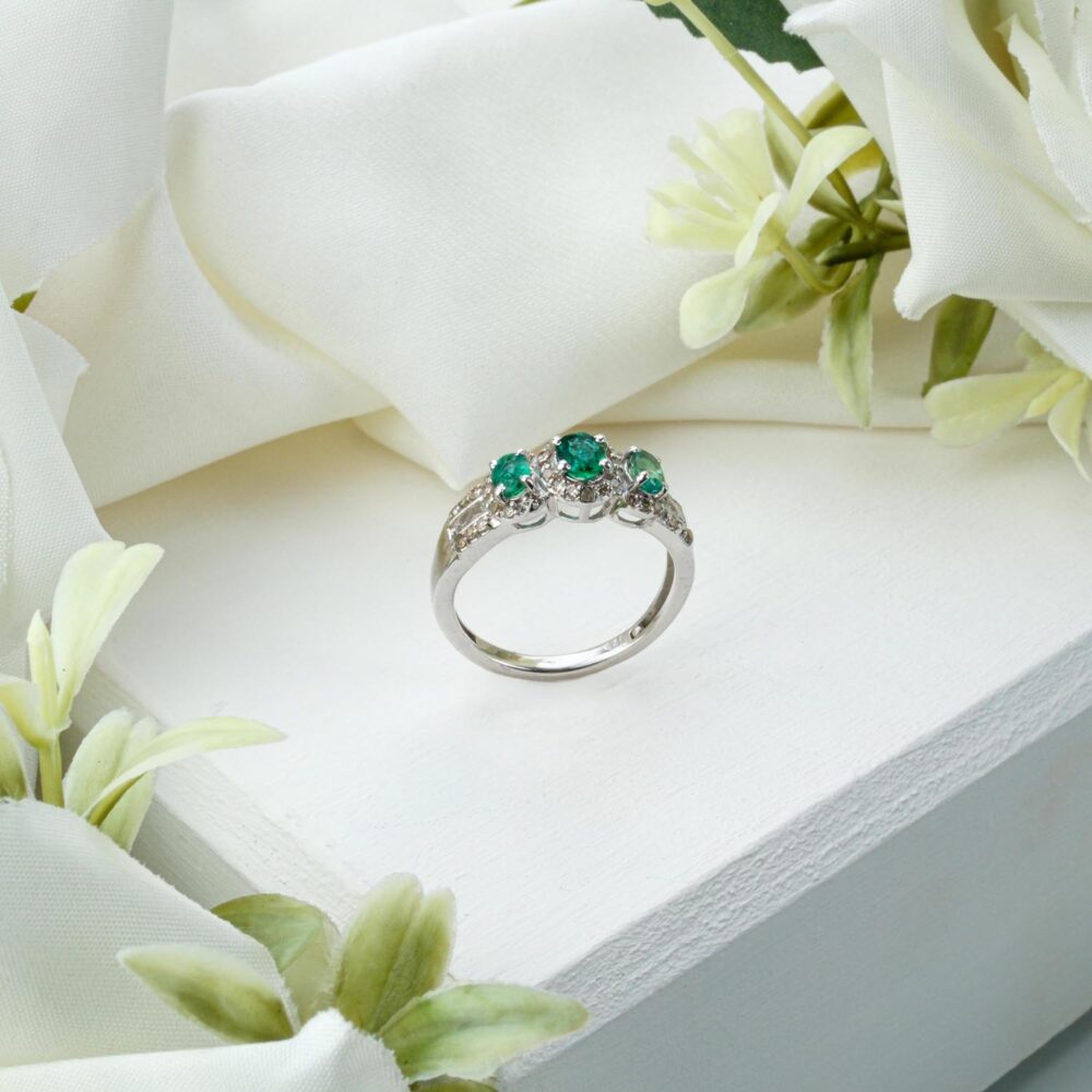 Genuine Zambian emerald ring with diamond accents in 925 sterling silver on white background