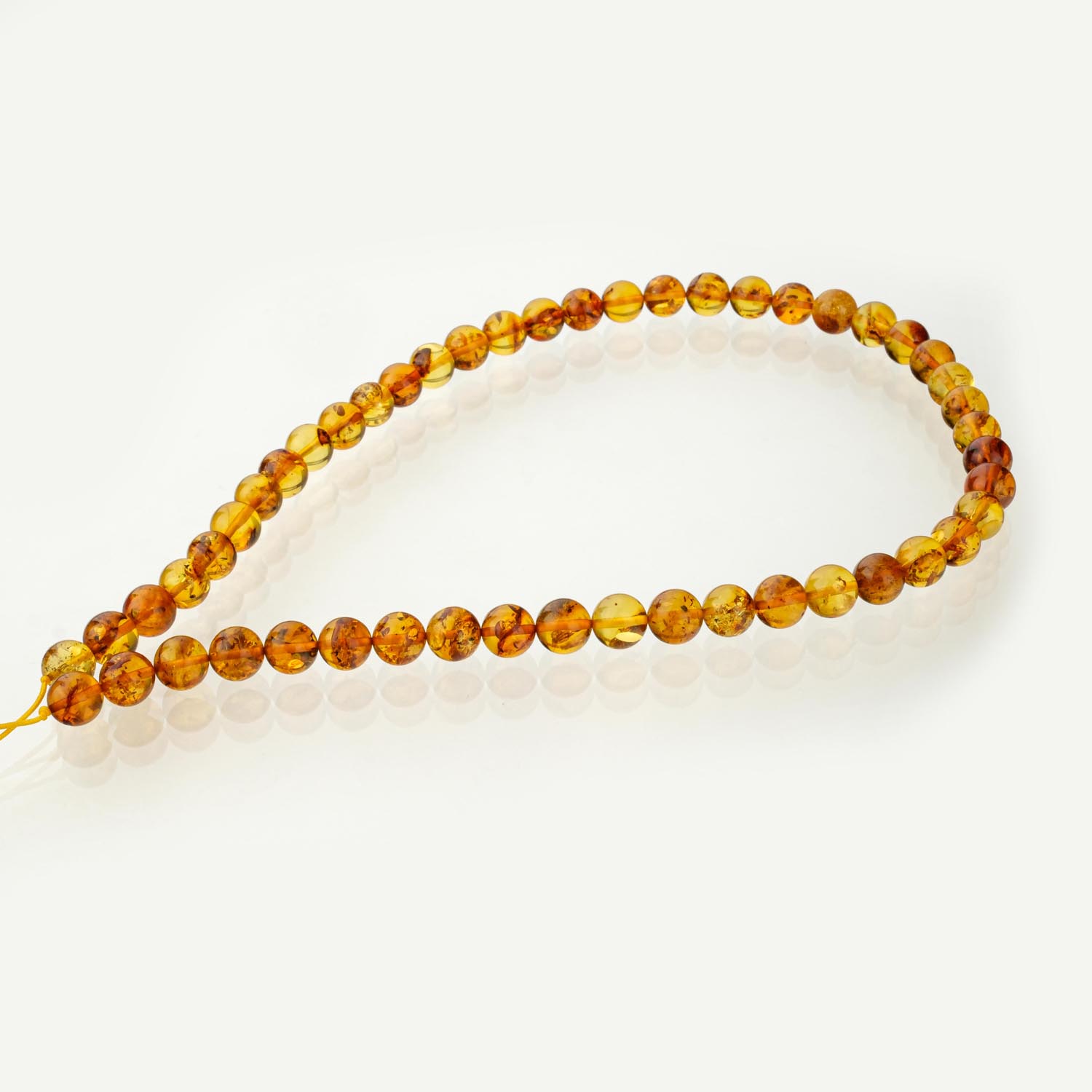 hebra-ambar-cognac-8mm Hebra de cuentas de ámbar coñac pulidas de 8mm sobre fondo blanco