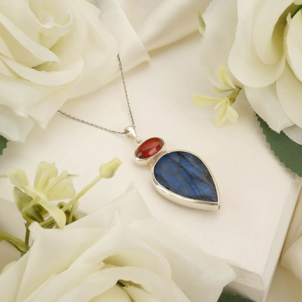 Teardrop labradorite and round garnet pendant necklace in 925 sterling silver on white background