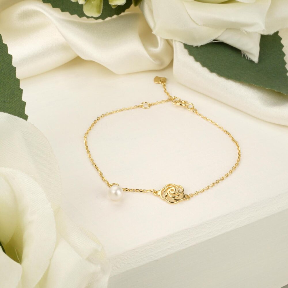 Delicate pearl and rose charm bracelet in 925 sterling silver with gold plating on white