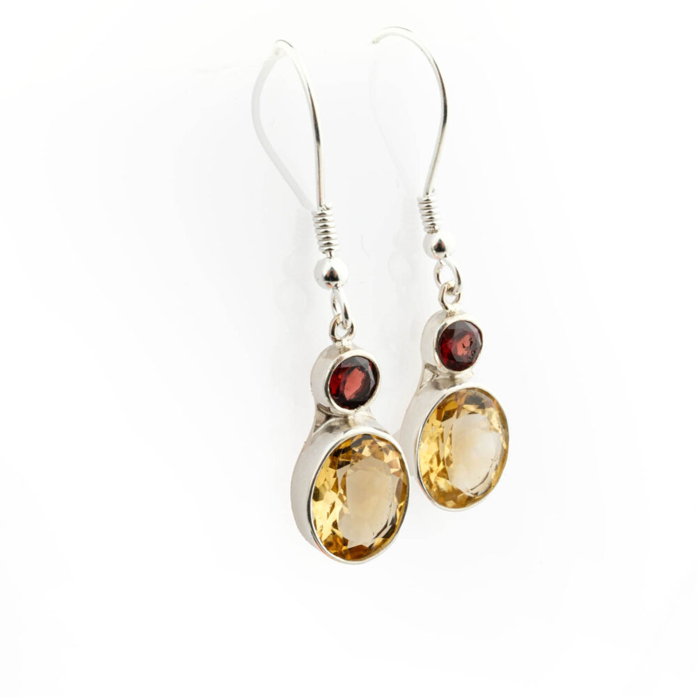 Pendientes premium de Citrino y Granate de dos piedras en plata 925, sobre satén marrón.