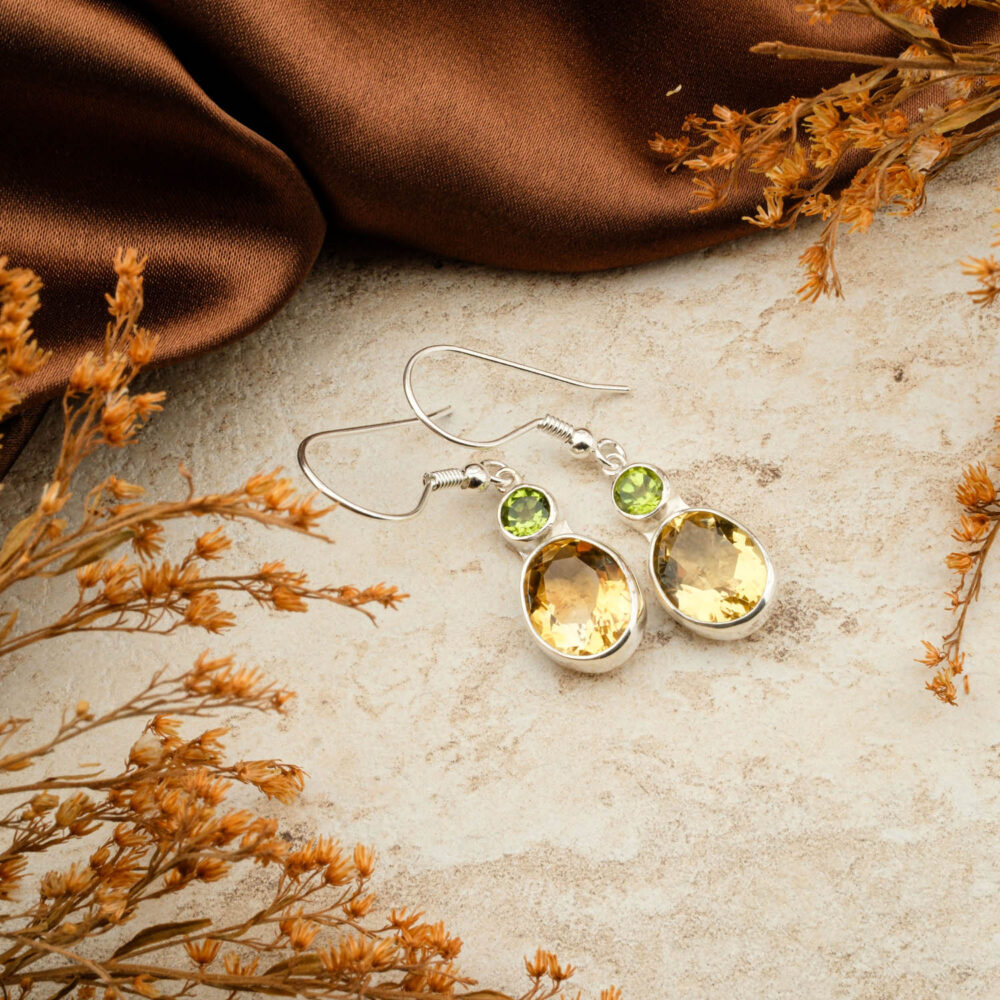 Premium Peridot (Zebercet) and Citrine two-stone earrings in 925 sterling silver, on a brown satin background.