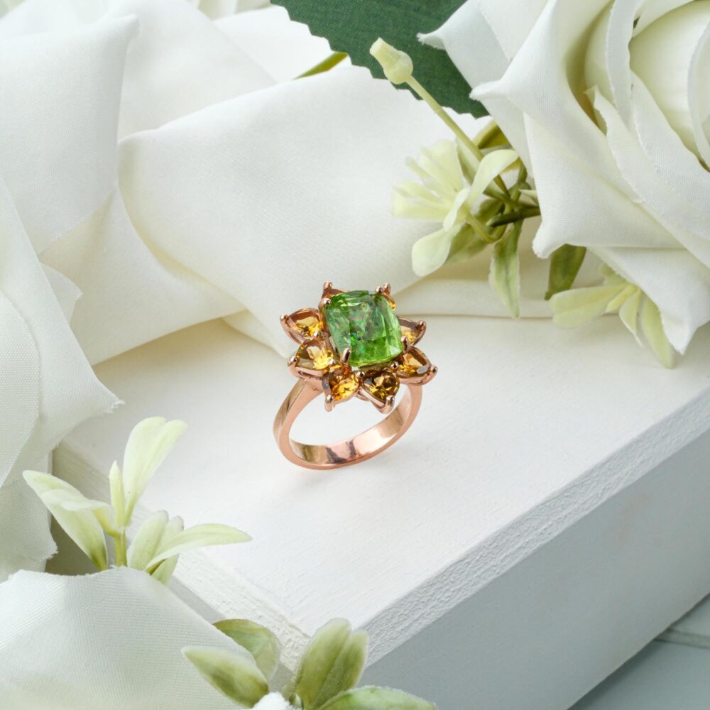 Floral ring with green peridot center and yellow citrine petals in rose gold-plated 925 silver on white