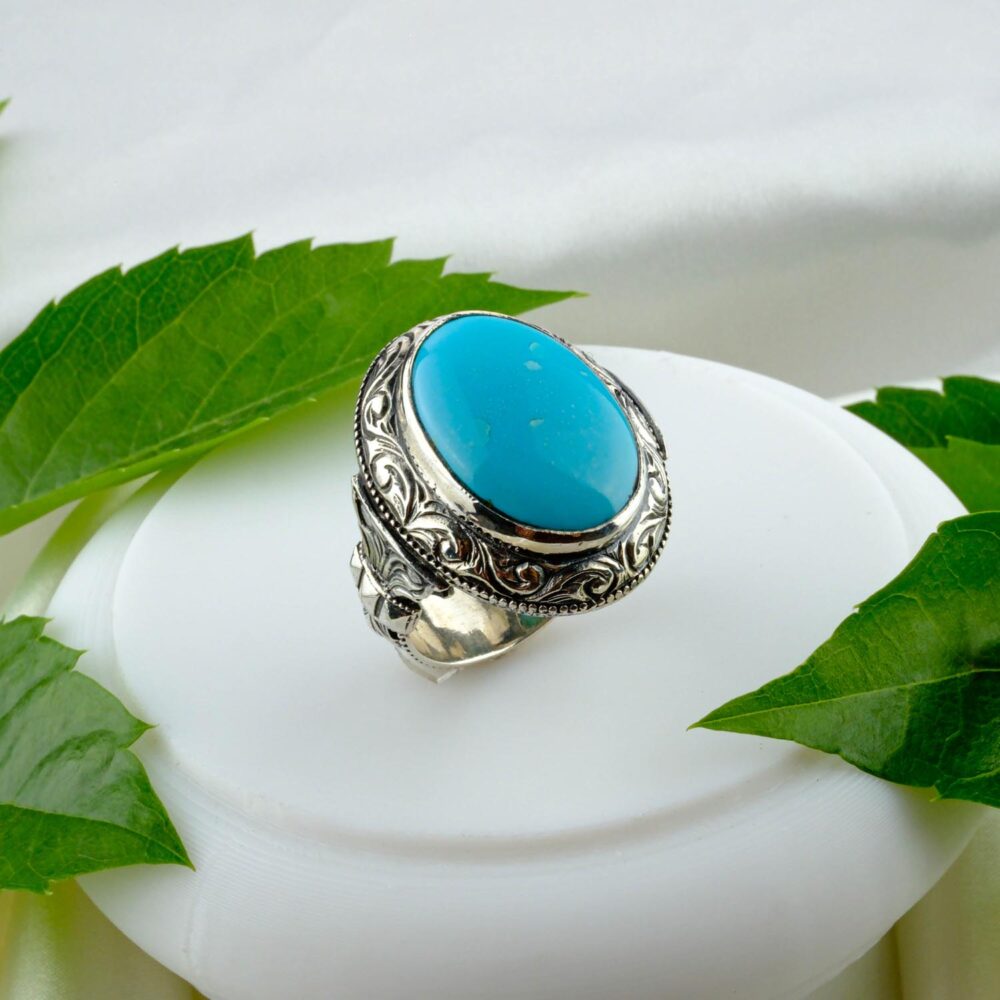 A men's 925 sterling silver ring with a large, oval, matrix-free Persian Turquoise, set in an intricately engraved oxidized band.
