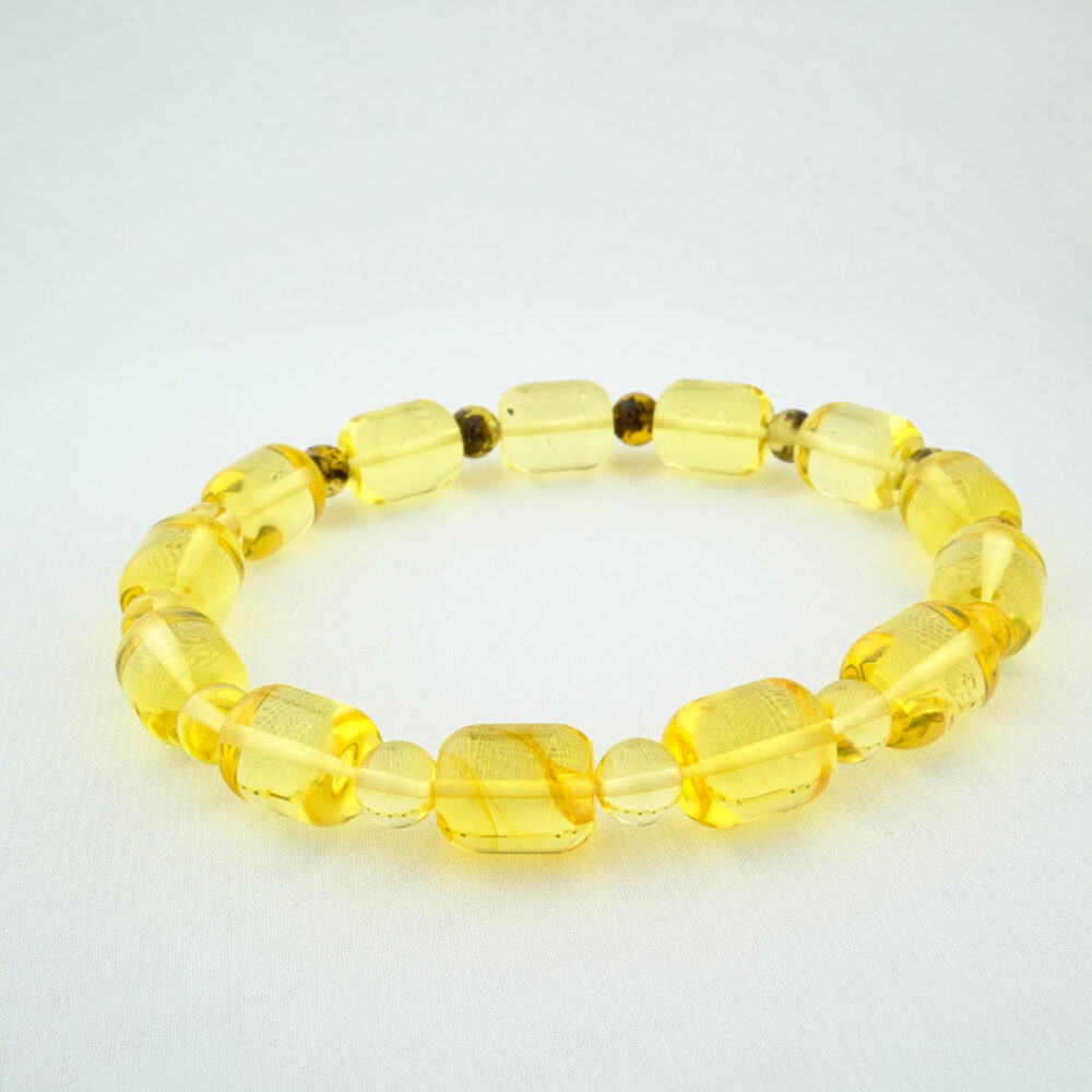 Pulsera de ámbar báltico certificada para adultos con cuentas claras de color limón en corte cápsula, sobre seda blanca.