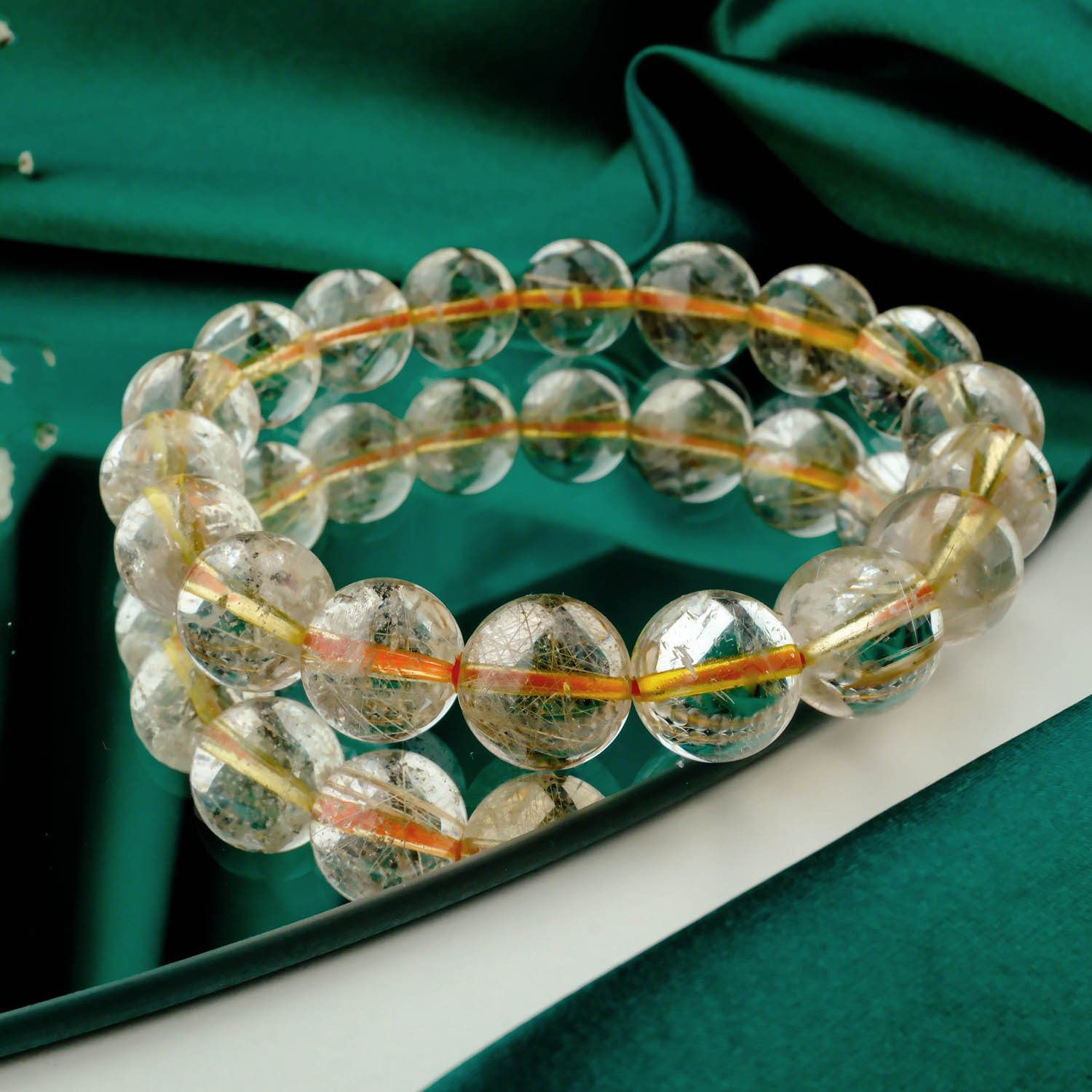 pulsera-cuarzo-rutilado-dorado-6a-10mm Pulsera de cuarzo rutilado dorado 6A+ con cuentas "cabello de ángel" de 9-10mm sobre fondo rojo