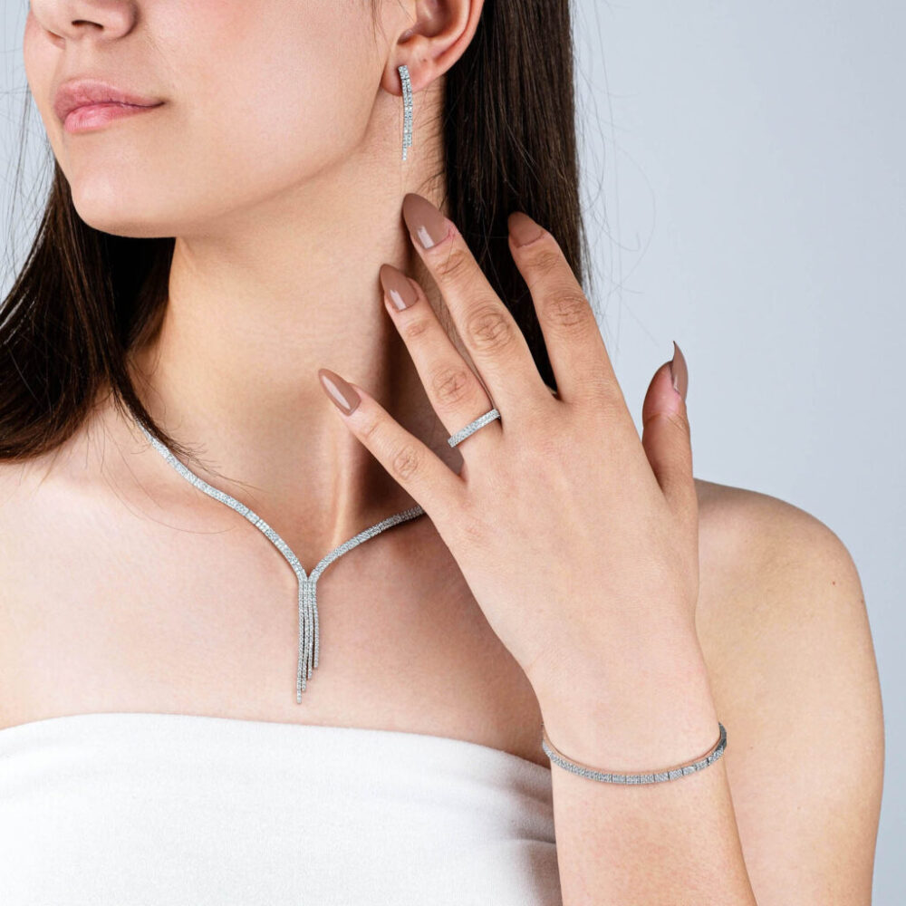 Complete silver tennis jewelry set with zircon necklace, bracelet, ring, and drop earrings on black background