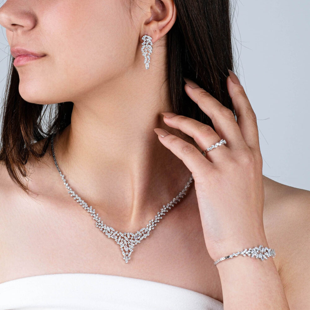 Complete silver tennis jewelry set with zircon necklace, bracelet, ring, and drop earrings on black background